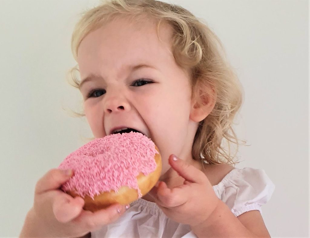 Girl eating doughnut.